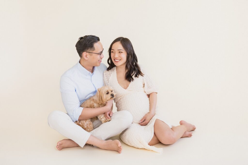 In studio maternity photography of couple with their pet
