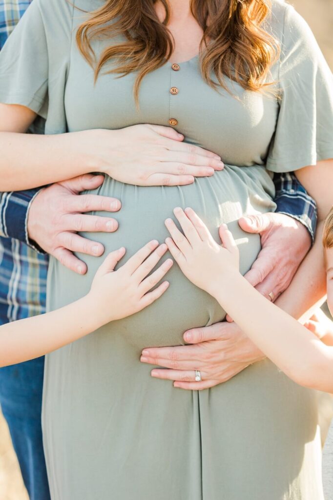 maternity photos of pregnant belly with hands touching it
