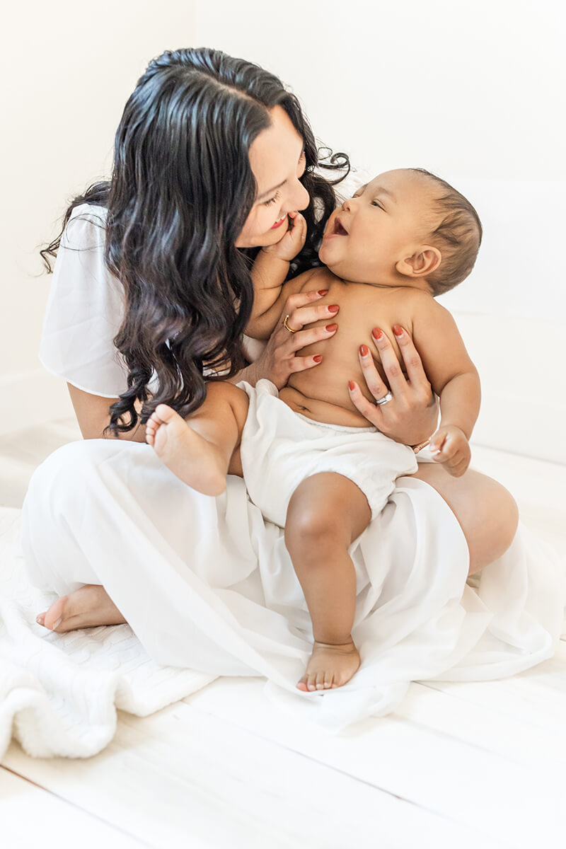 Little boy held by mom looking at the camera by Bay Area Family Photographer