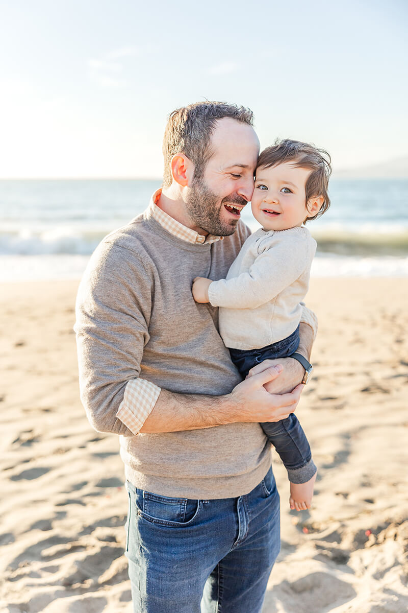 Father kissing baby girl on San Francisco beach by Bay Area Family Photographer
