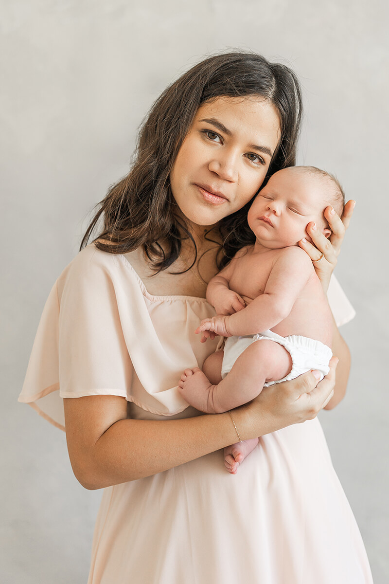Mom holding baby boy close to her cheek in a newborn session with a bay area newborn photographer