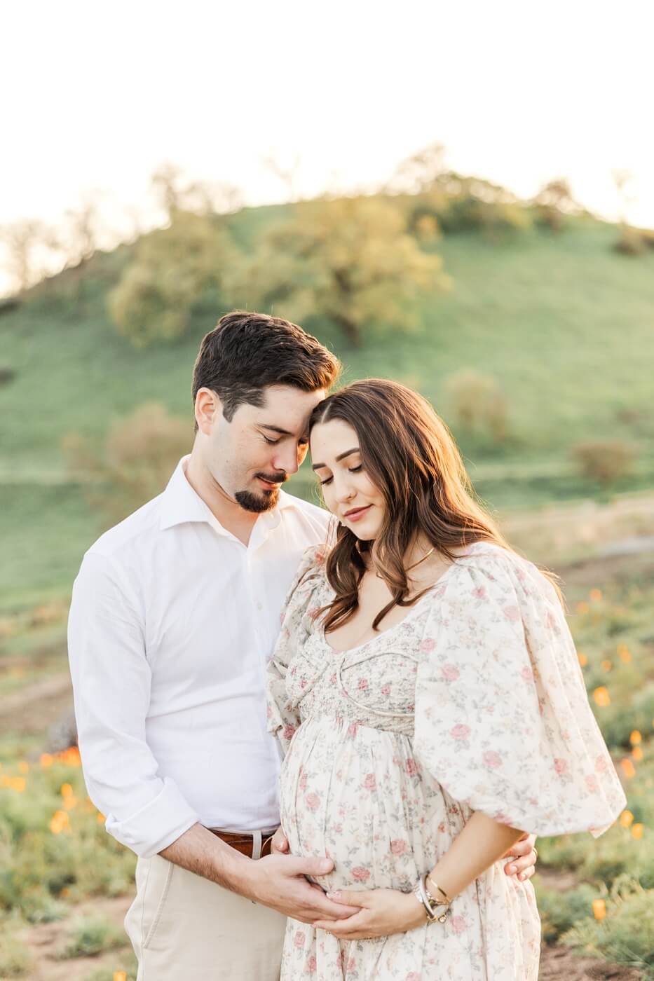 dad holding belly of pregnant mom outside in the San Francisco Bay Area