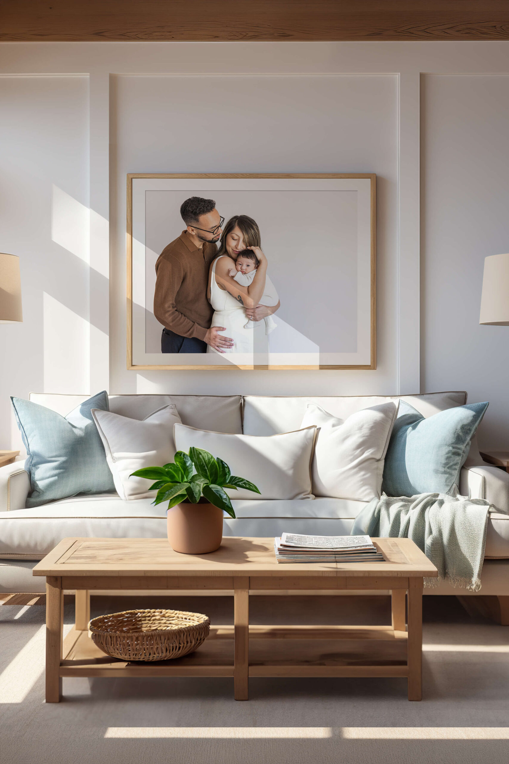 Framed artwork over sofa of a baby being held by parents